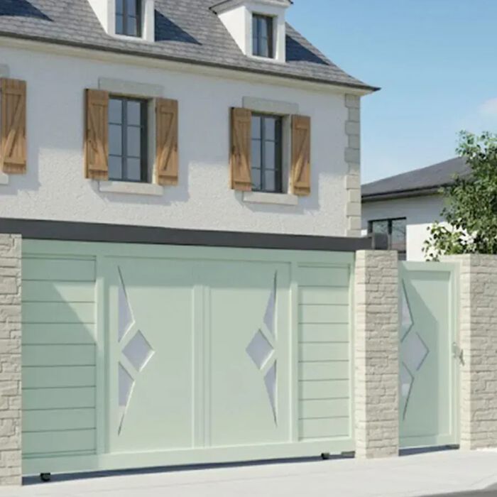 Portail coulissant SCILL vert pâle devant une maison en pierre