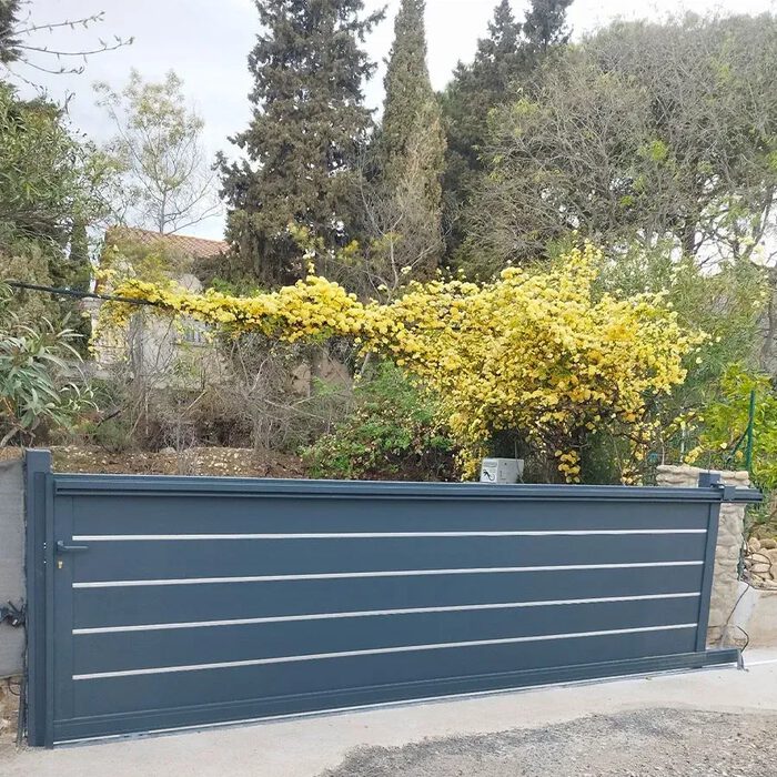 Portail coulissant TAY gris ardoise devant un jardin