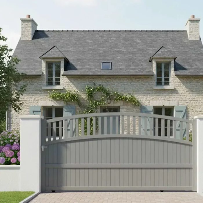 Portail coulissant TOM gris clair devant une maison en pierre