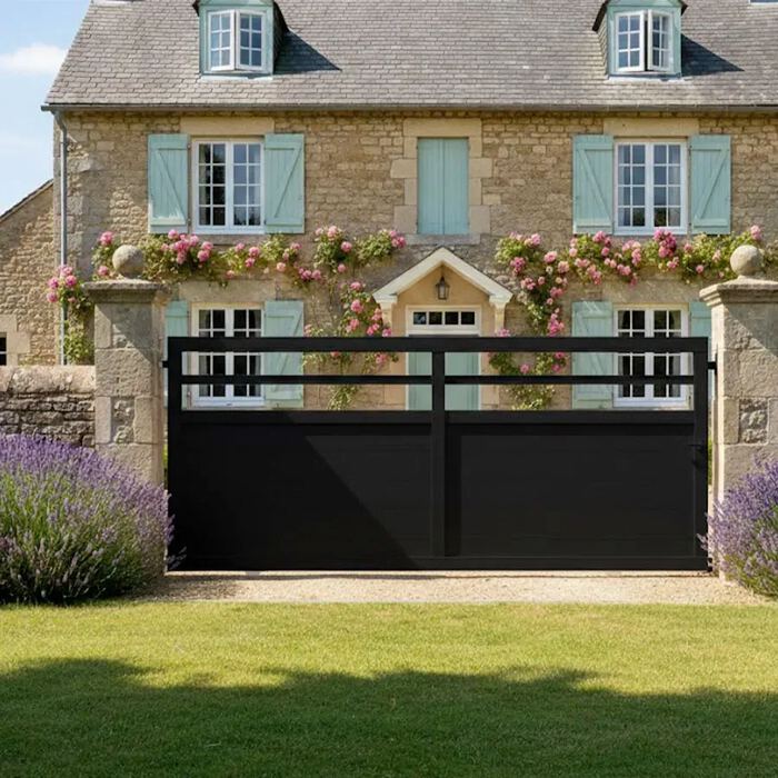 Portail coulissant TROM noir devant une maison en pierre