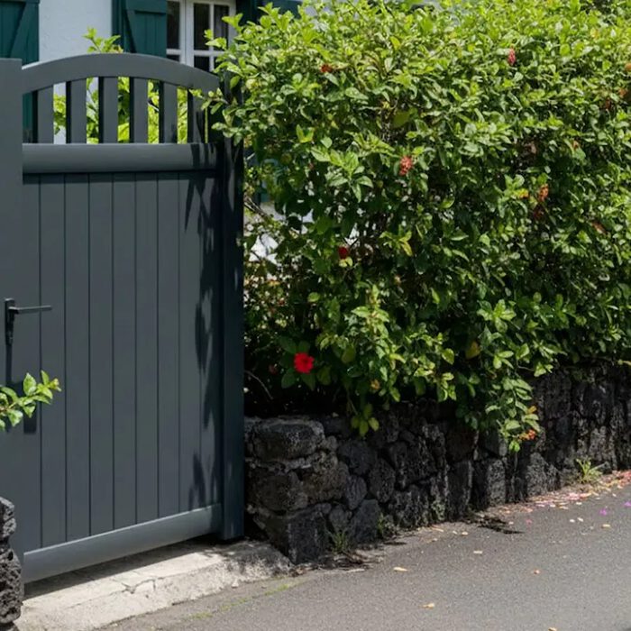 Portillon aluminium ARA gris anthracite le long d'une haie