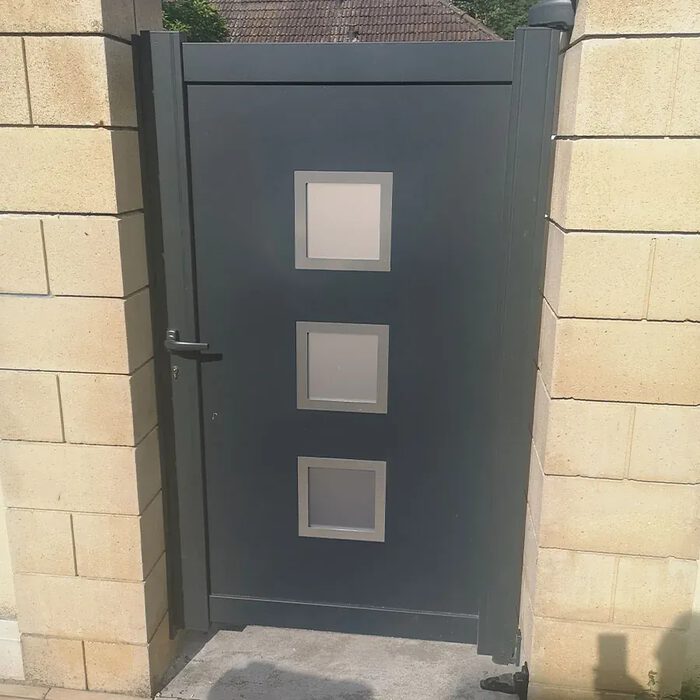 Portillon aluminium ARSE gris anthracite devant une maison en pierre