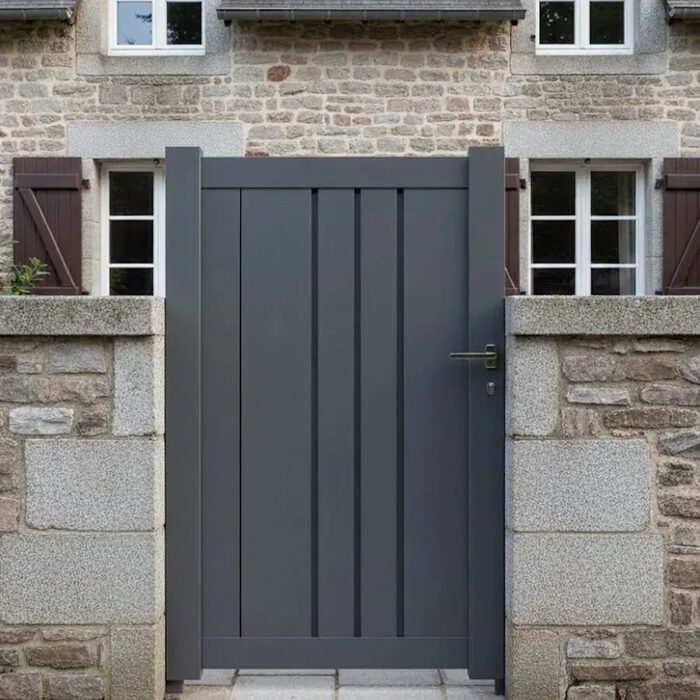 Portillon aluminium BAFFIN gris anthracite devant une maison en pierre