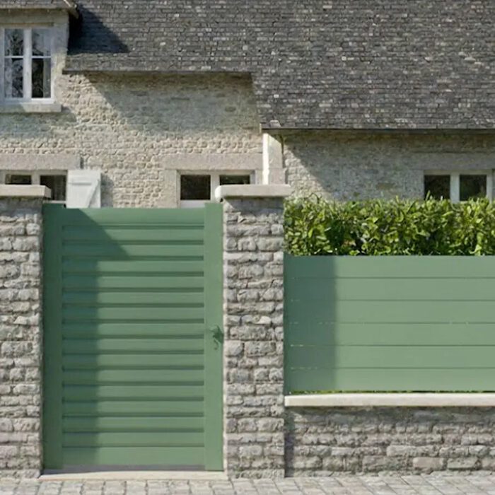 Portillon aluminium BAGO vert devant une maison en pierre