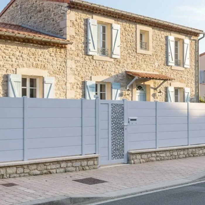 Portillon aluminium BARBUDA gris clair devant une maison en pierre