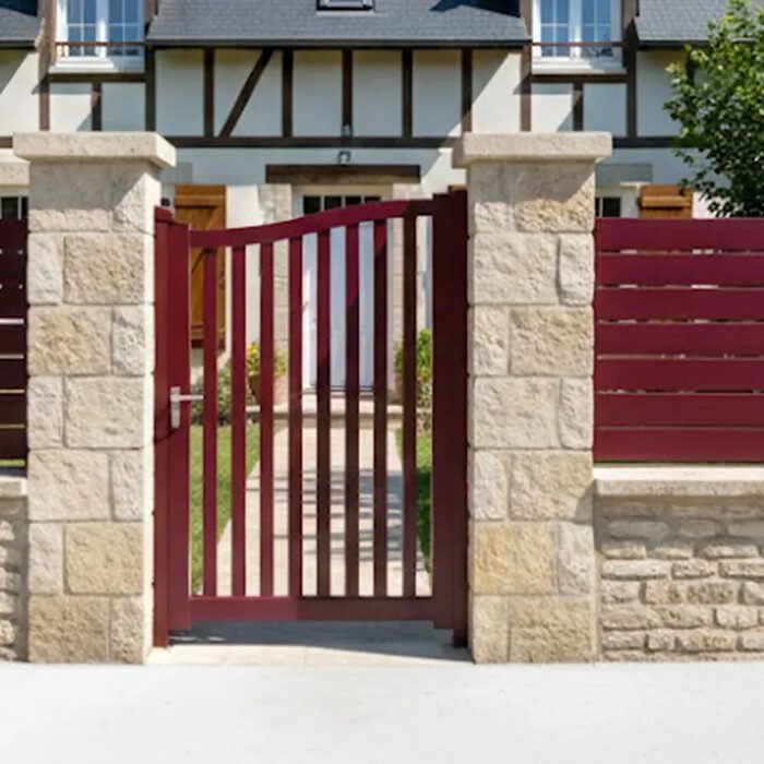 Portillon aluminium BERI rouge devant une maison normande