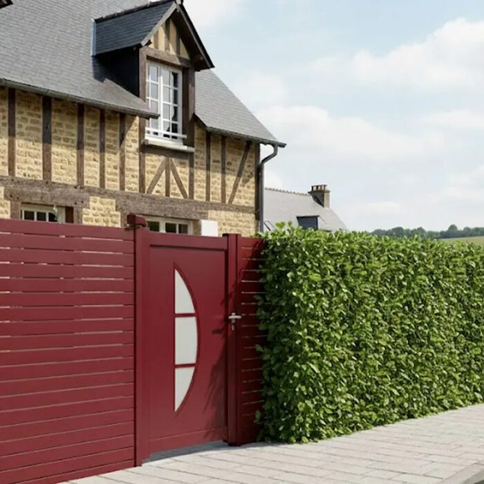 Portillon aluminium BYL rouge bordeaux devant une maison normande