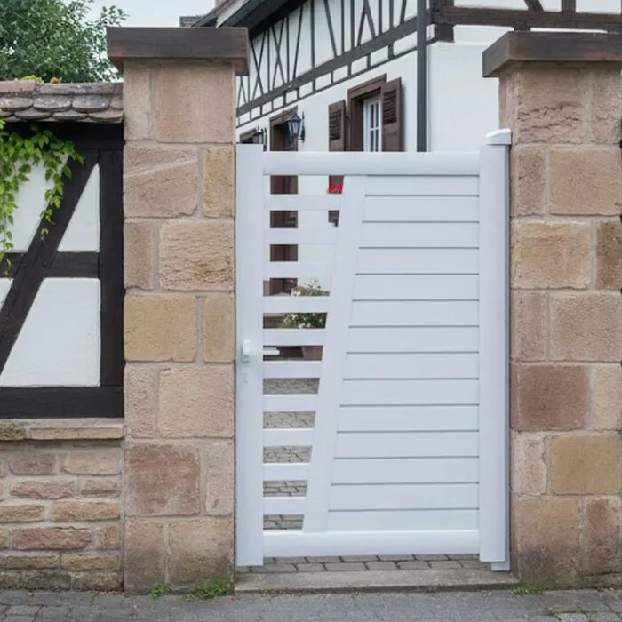 Portillon aluminium COLN blanc devant une maison à colombages