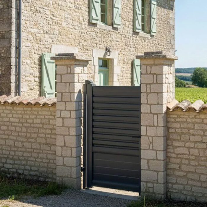 Portillon aluminium DAD gris anthracite entre deux piliers en pierre