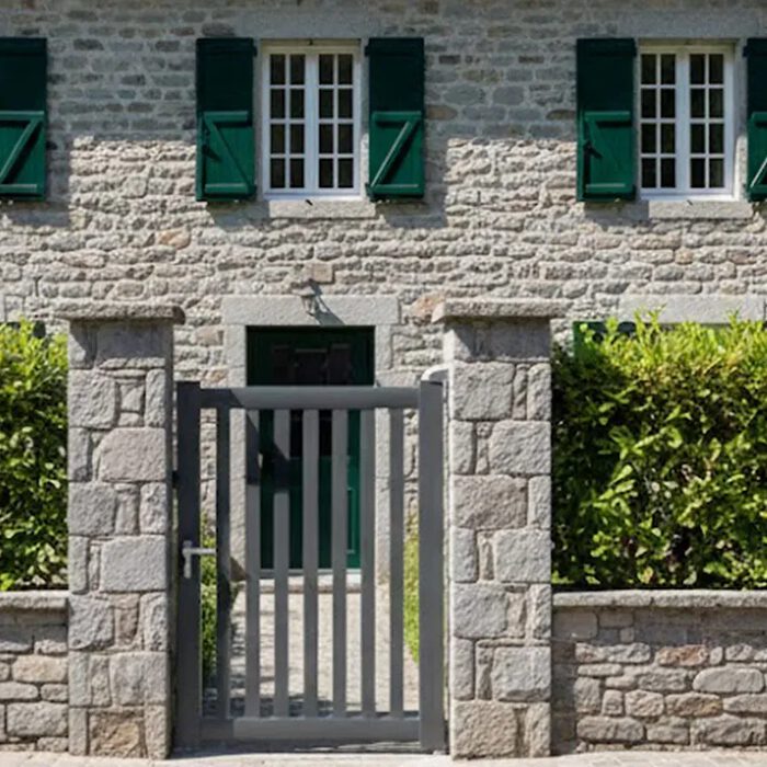Portillon aluminium DEN gris anthracite devant une maison en pierre