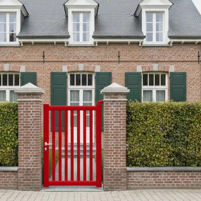 Portillon aluminium DEN rouge devant une maison de maître