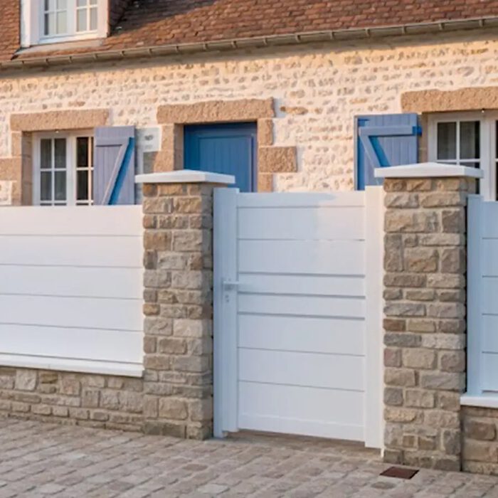 Portillon aluminium DEVON blanc devant une maison en pierre