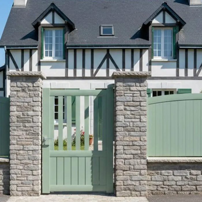 Portillon aluminium KIN vert amande devant une maison normande