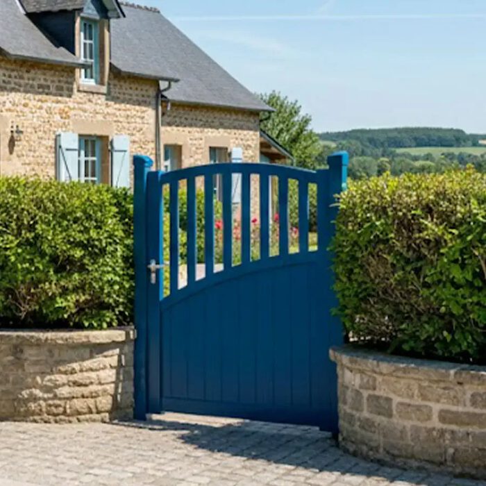 Portillon aluminium LANZA bleu devant une maison en pierre