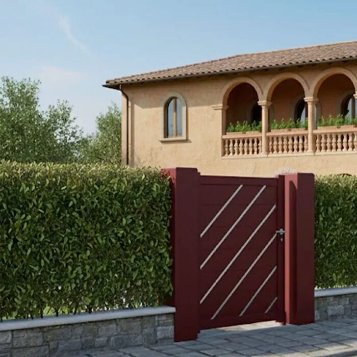 Portillon aluminium LESM rouge bordeaux devant une maison en pierre