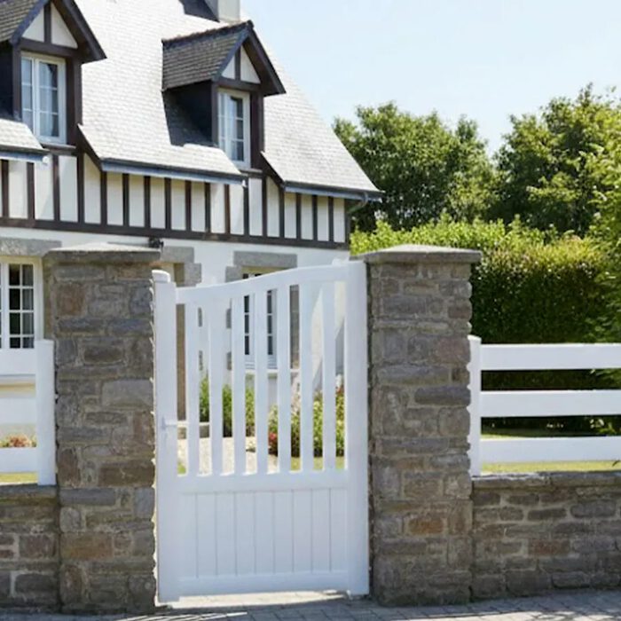 Portillon aluminium LEV blanc devant une maison normande