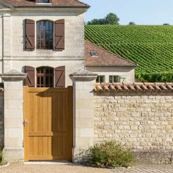 Portillon aluminium MEL chêne doré devant une maison de vigneron
