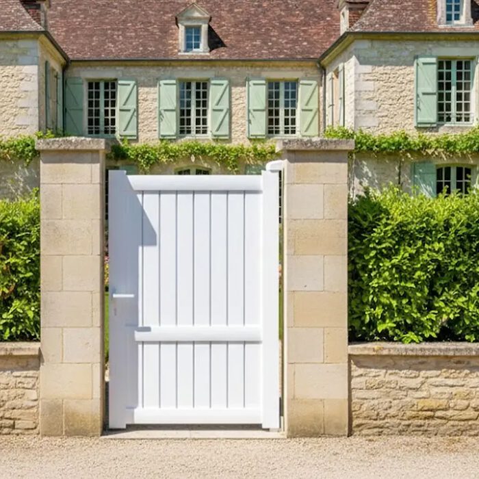 Portillon aluminium MEL blanc devant une maison à volets verts
