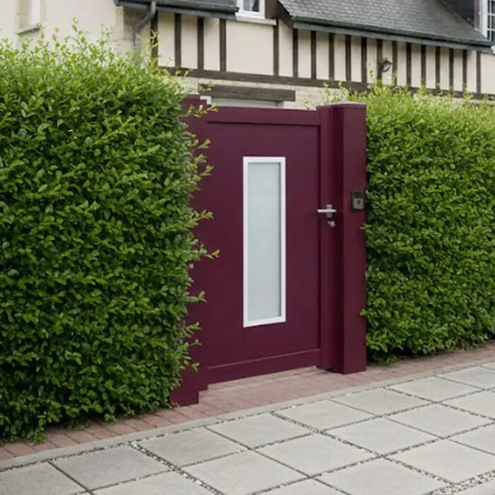 Portillon aluminium ORC bordeaux le long d'une haie