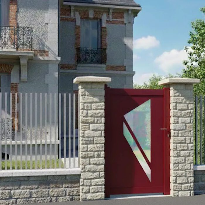 Portillon aluminium PRIBI rouge devant une maison en pierre