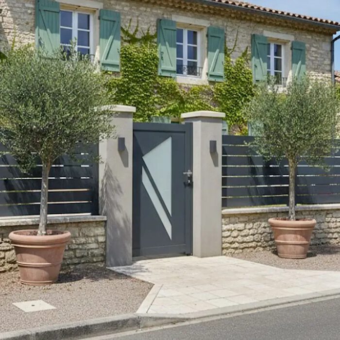 Portillon aluminium PRIBI anthracite posé entre deux piliers en pierre