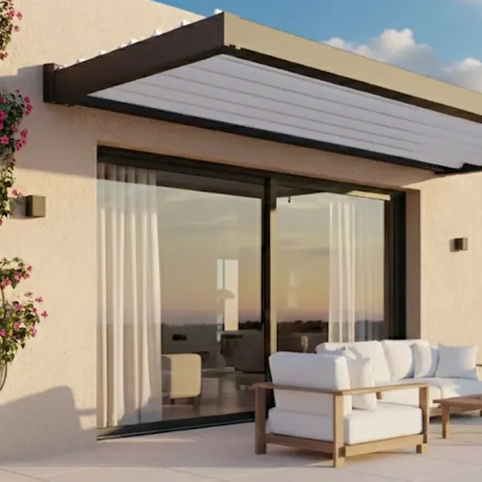 Auvent brise-soleil aluminium au-dessus d'une baie vitrée ouverte sur une terrasse meublée