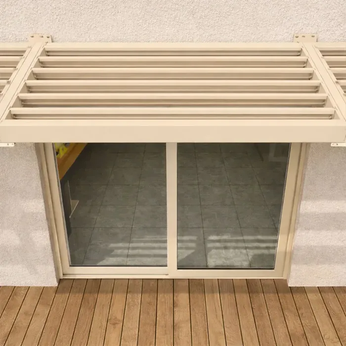 Auvent brise-soleil à lames fixes de teinte ivoire clair au-dessus d'une baie vitrée sur une terrasse en bois