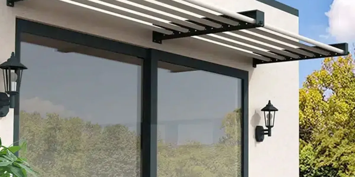 Auvent brise-soleil à lames fixes en aluminium anthracite au-dessus d'une grande baie vitrée sur une façade blanche