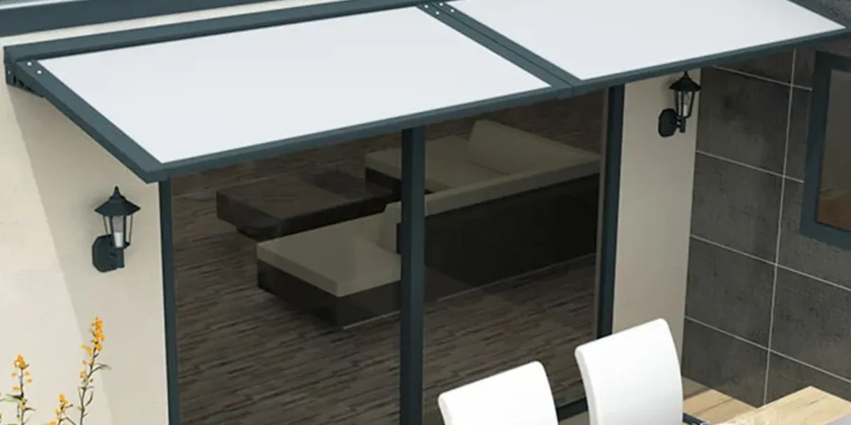 Auvent fixe en aluminium anthracite à panneau isolant installé au-dessus d'une grande baie vitrée de terrasse