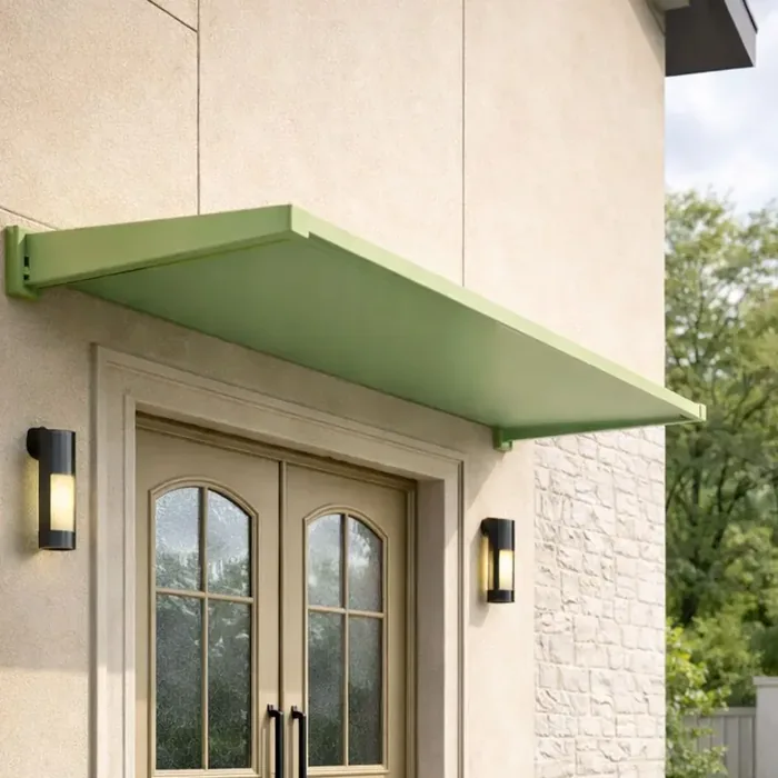 Auvent fixe vert RAL 6021 installé au-dessus d'une porte d'entrée beige sur façade claire