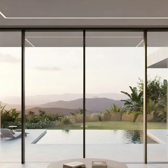Baie coulissante aluminium 4 vantaux noire vue de l'intérieur d'un séjour, ouverte sur une piscine