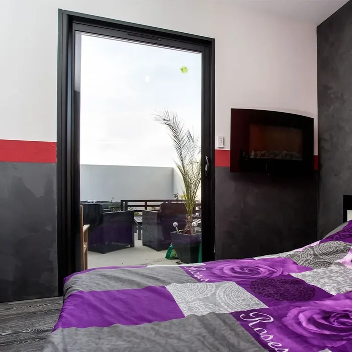 Galandage 1 vantail noir dans une chambre, ouvert sur un balcon