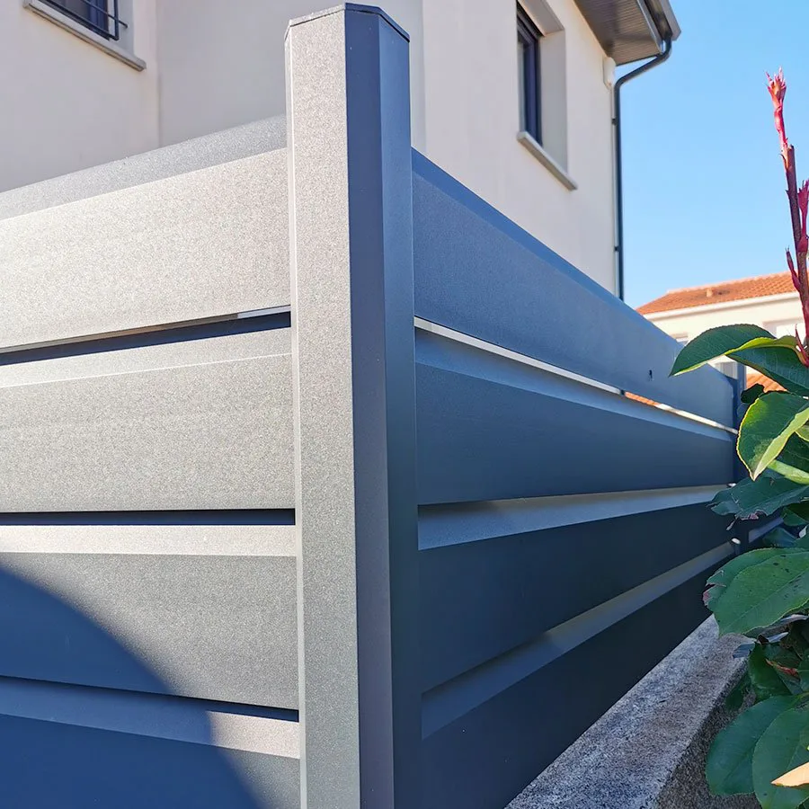 Gros plan sur les lames d'une clôture brise vue aluminium bleue et son poteau d'angle