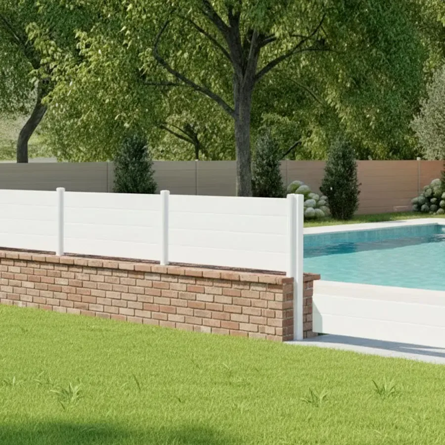 Clôture aluminium blanche basse à lames pleines posée sur un muret en briques au bord d'une piscine