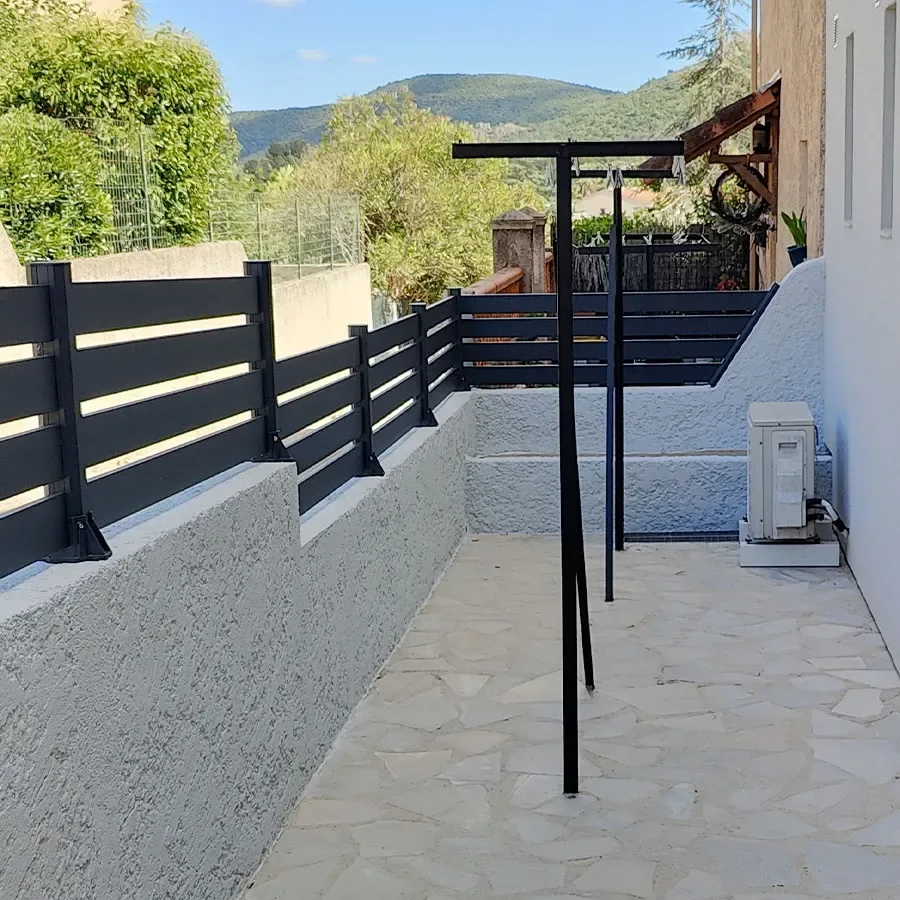 Clôture aluminium anthracite à grandes lames ajourées en situation sur une terrasse en hauteur