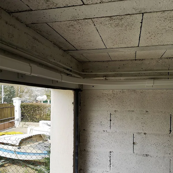 Angle du rail haut d'une porte de garage à enroulement latéral, vu depuis l'intérieur du garage