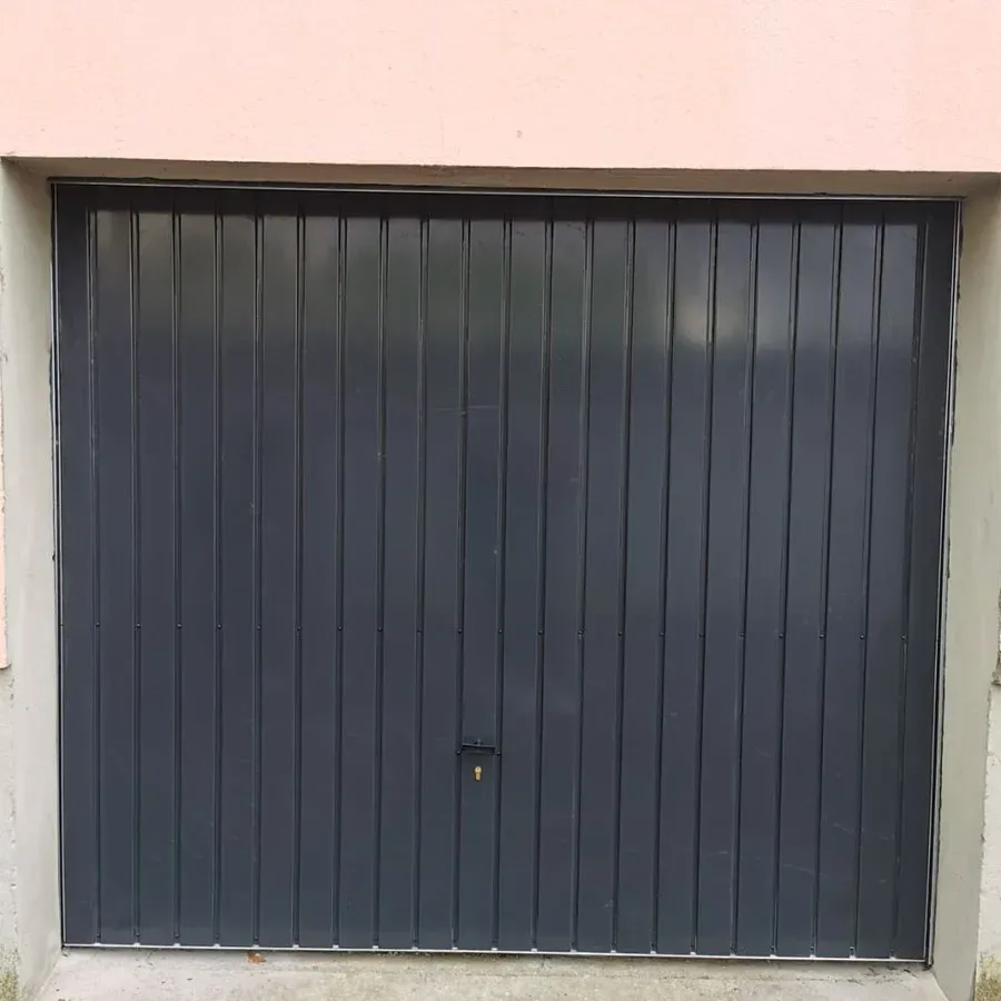 Porte de garage basculante gris foncé à nervures verticales, vue de face