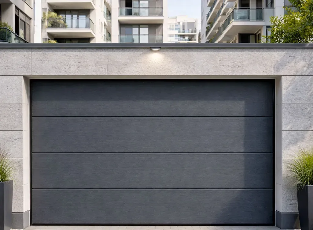 Porte sectionnelle de garage anthracite intégrée à un immeuble résidentiel en environnement urbain
