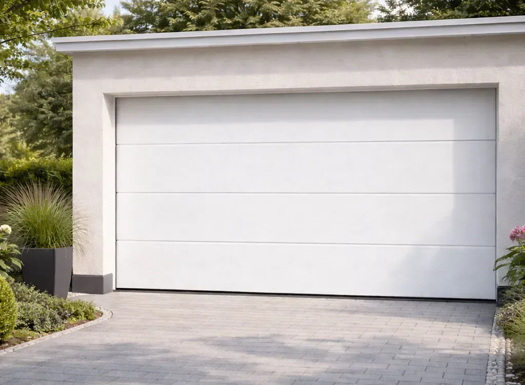 Porte sectionnelle de garage blanche sur maison individuelle avec allée pavée et jardin paysager