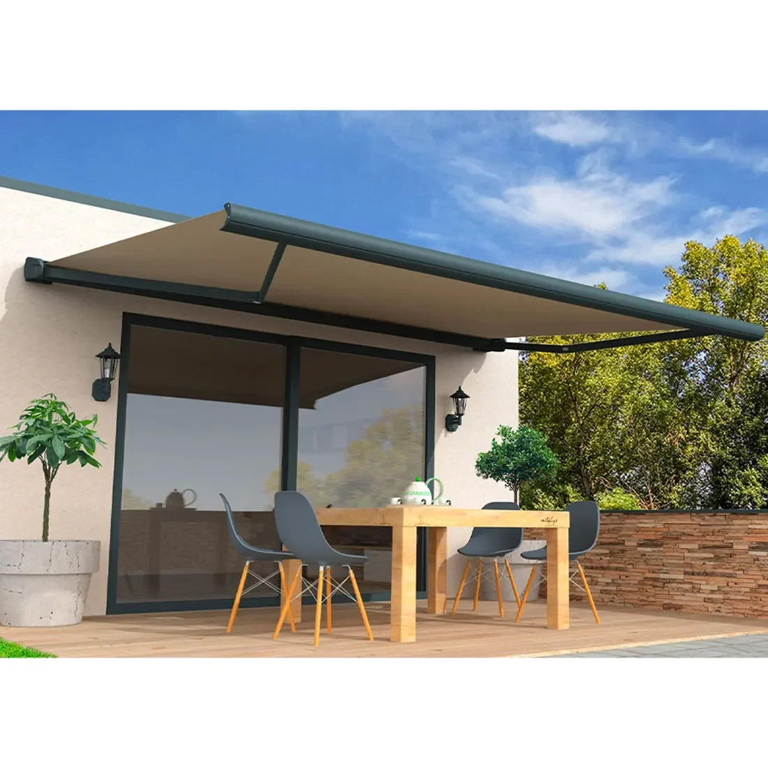 Store banne à coffre taupe déployé au-dessus d'une terrasse en bois avec table et chaises