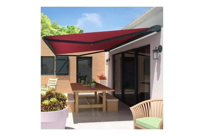 Store banne à coffre avec toile rouge bordeaux déployée au-dessus d'une terrasse