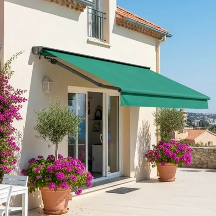 Store banne à coffre avec toile verte déployée sur la terrasse d'une villa