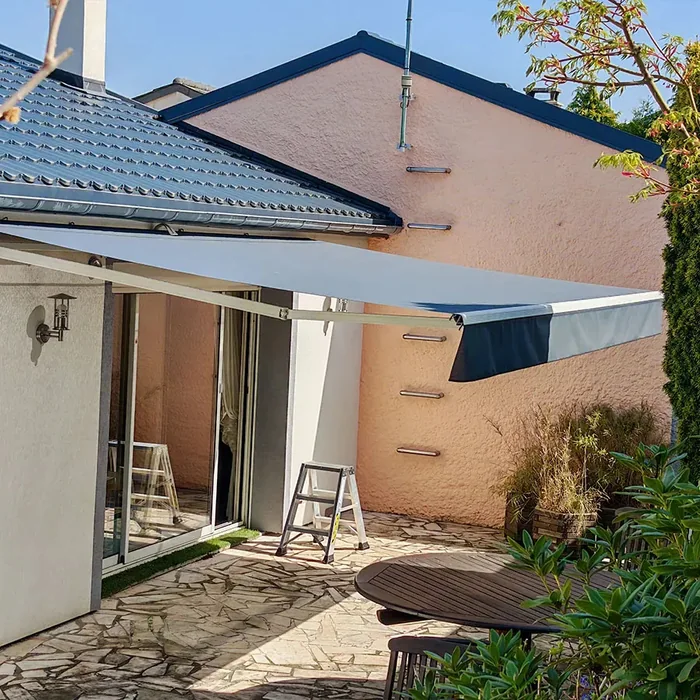 Store banne 2 bras bleu et blanc posé sur une maison