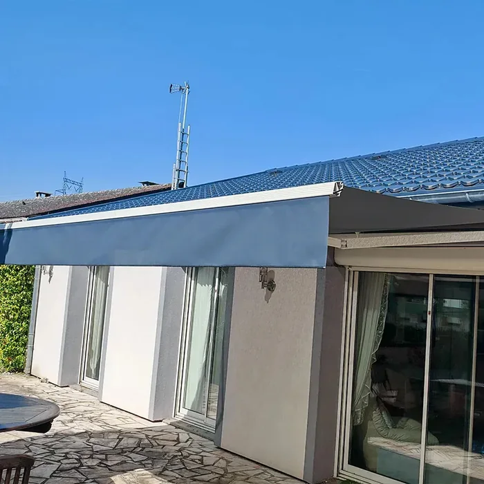 Store banne bleu posé en façade, vue rapprochée du cache tube et de la fixation murale