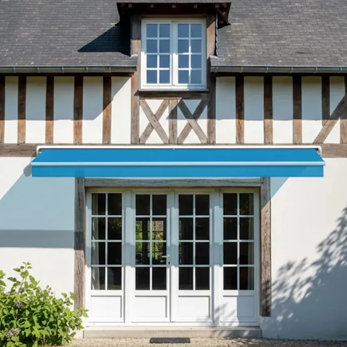Store banne 2 bras bleu sur une maison à colombages