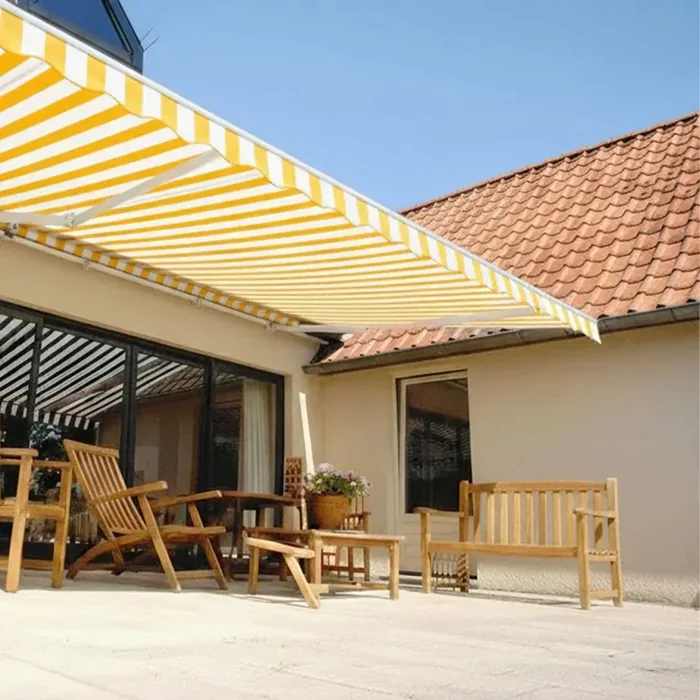 Store banne 2 bras à toile rayée jaune et blanc au-dessus d'une terrasse