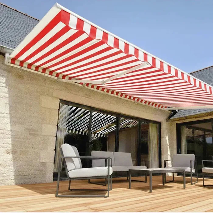 Store banne 4 bras rayé rouge et blanc sur une terrasse en bois