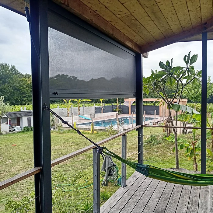 Store vertical à toile Soltis vu depuis l'intérieur d'une terrasse couverte en bois