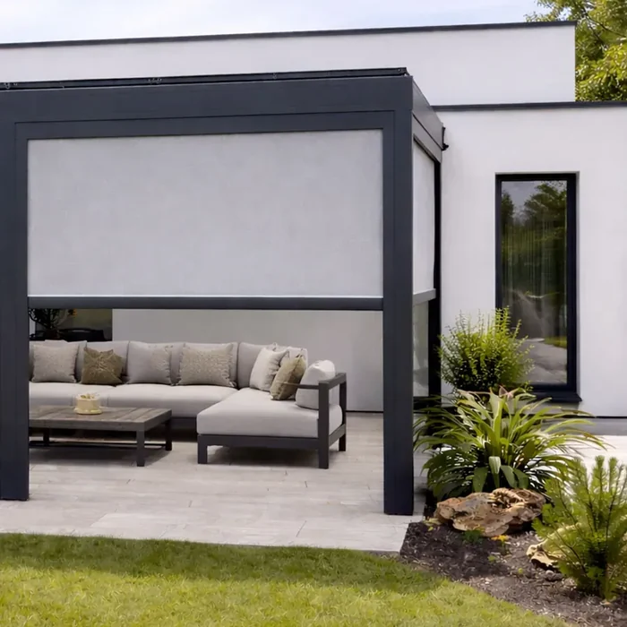 Pergola aluminium anthracite avec store vertical à toile grise sur une terrasse en travertin