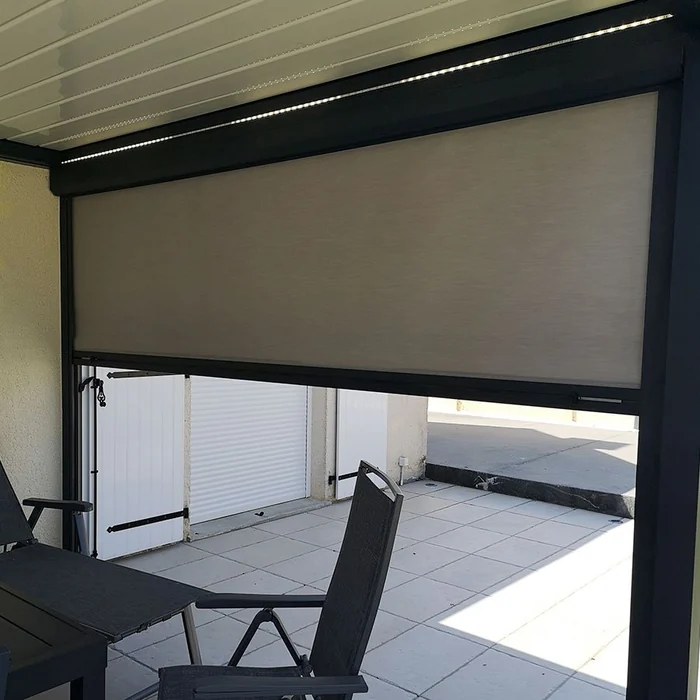 Store vertical à toile enroulante sur une terrasse de pergola aluminium